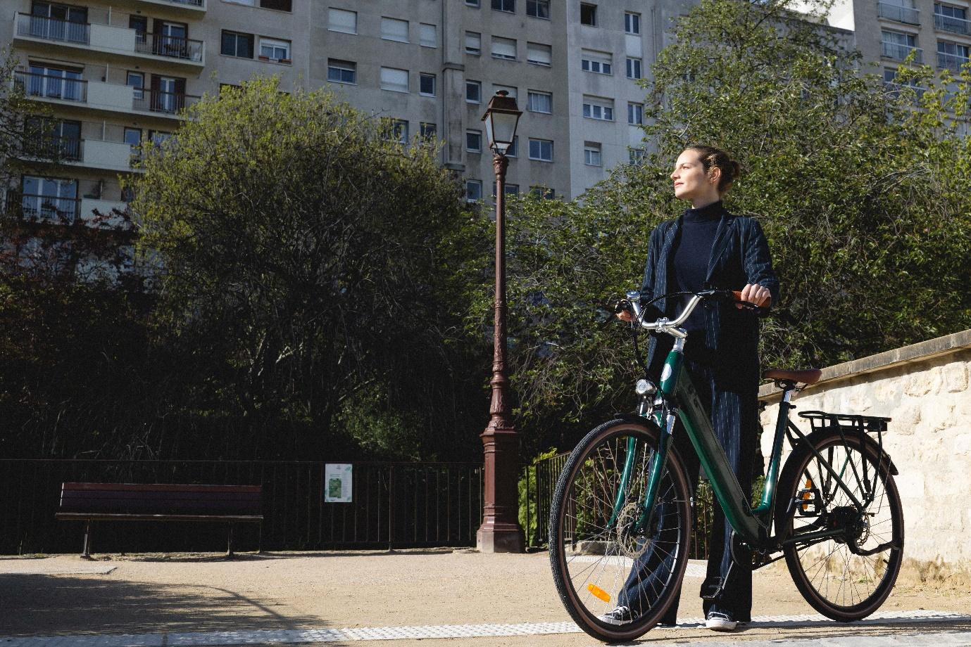 Une femme dans un parc avec un vélo électrique de ville